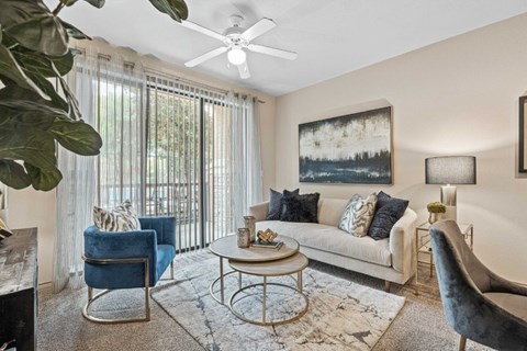 A living room with a blue chair and a white couch.